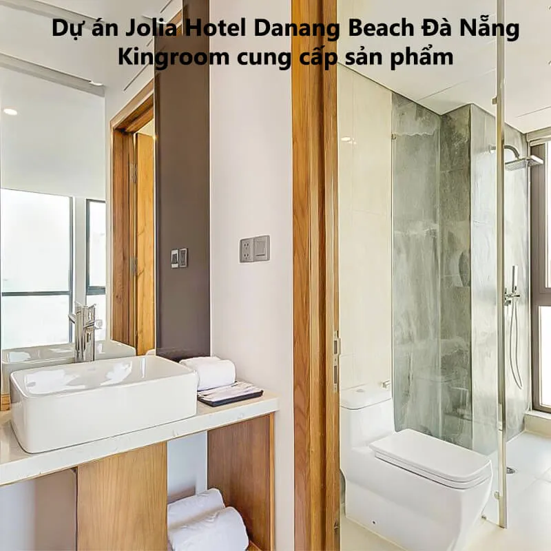 Phòng tắm với lavabo và kính tắm đứng tại Jolia Hotel Danang Beach Đà Nẵng.