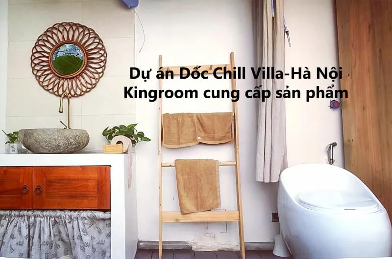 Lavabo đá và gương tròn tại phòng tắm Dốc Chill Villa - Hà Nội.