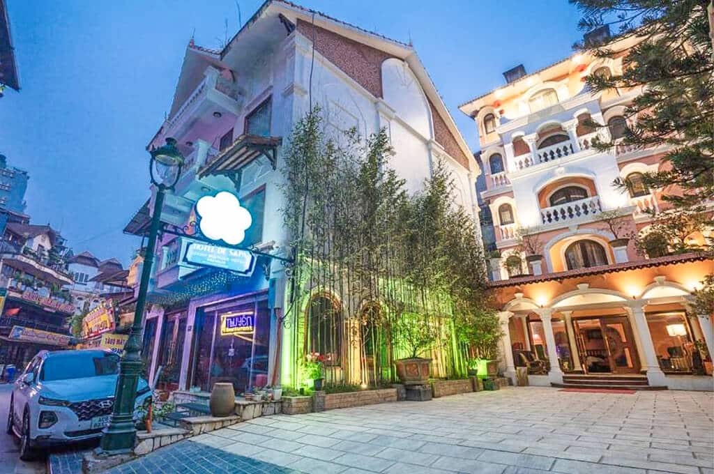 Mặt tiền Hotel De Sapa với ánh đèn ban đêm và cảnh quan xung quanh.