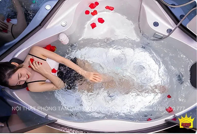 Người phụ nữ thư giãn trong bồn tắm jacuzzi của Phòng Xông Hơi Ướt SC30, trang trí bằng cánh hoa hồng, tạo không gian thư giãn và sang trọng.