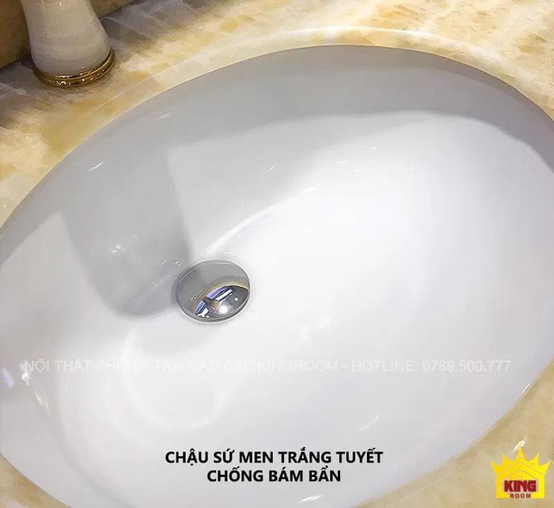 Chậu sứ mền trắng tuyết chống bám bẩn, tích hợp trong tủ lavabo với mặt đá cẩm thạch tự nhiên, thiết kế thông minh và thanh lịch