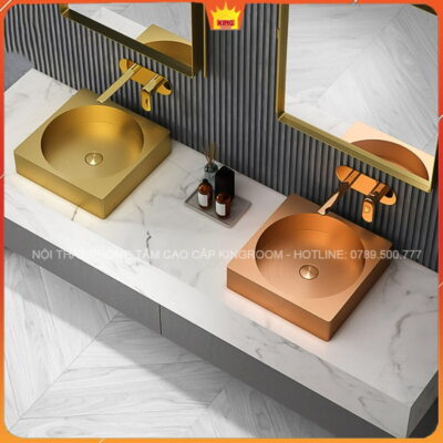 Hai Lavabo Inox Aqua GS40 màu vàng chải và vàng hồng trên kệ đá.