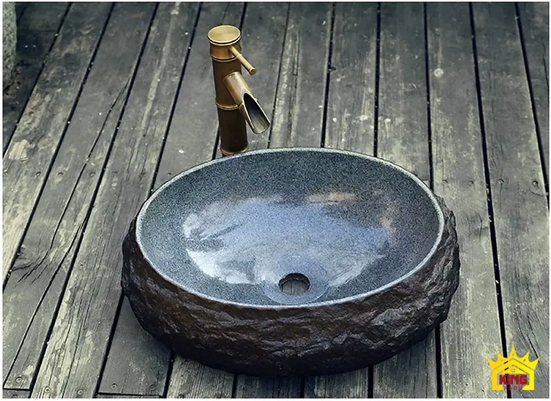 Góc nghiêng chậu lavabo đá cuội oval Lavabo đá cuội tự nhiên oval nhìn nghiêng trên mặt bàn gỗ