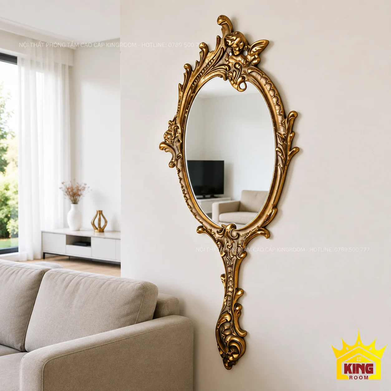 Gương oval vàng đồng trang trí phòng khách Gương oval cổ điển đuôi dài trên tường sáng màu cạnh sofa kem trong phòng khách