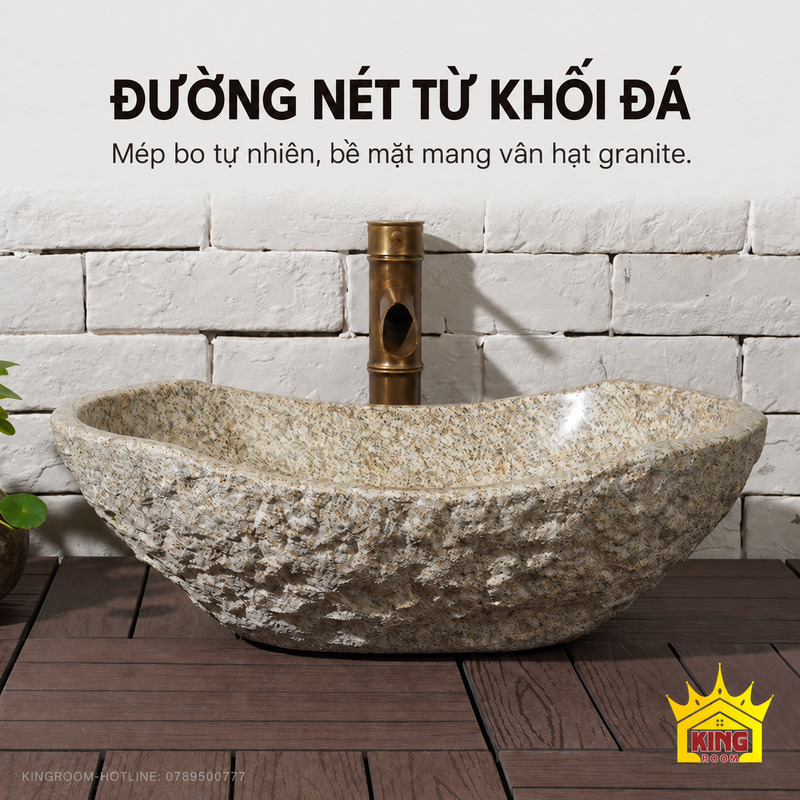 Góc nhìn thấp thể hiện mép bo không đều và thân đá thô của lavabo đá cuội nguyên khối xám be